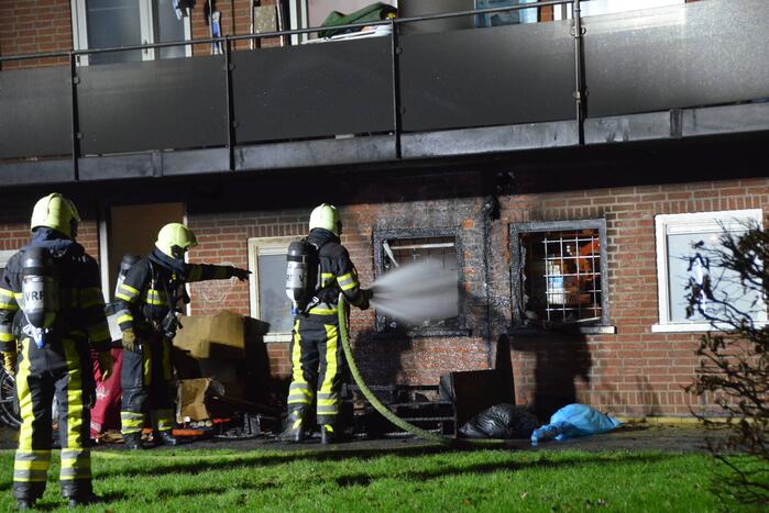 Bank in brand onder balkon van flat