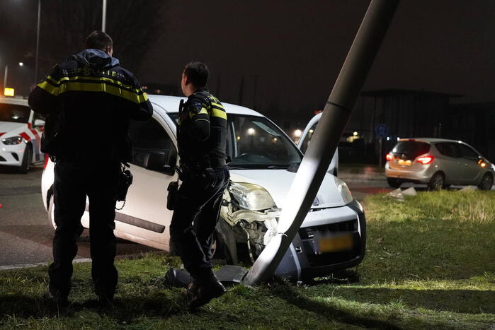 Bestelwagen klapt op lantaarnpaal