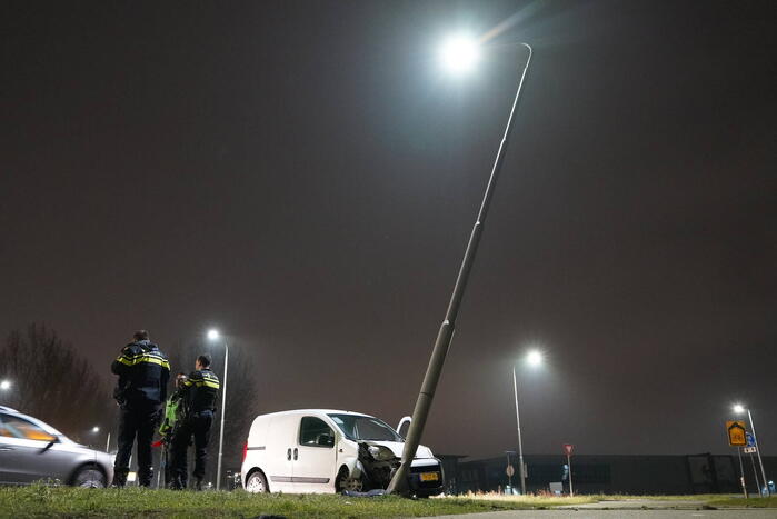 Bestelwagen klapt op lantaarnpaal