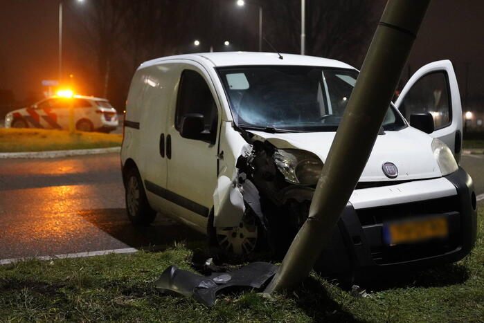 Bestelwagen klapt op lantaarnpaal