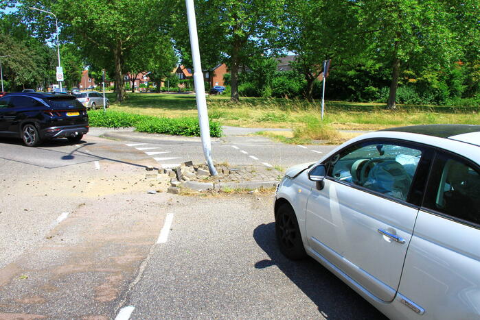 Automobilist ramt paal en lantaarnpaal bij rotonde