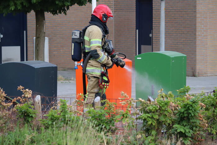 Gedumpt afval bij containers in brand