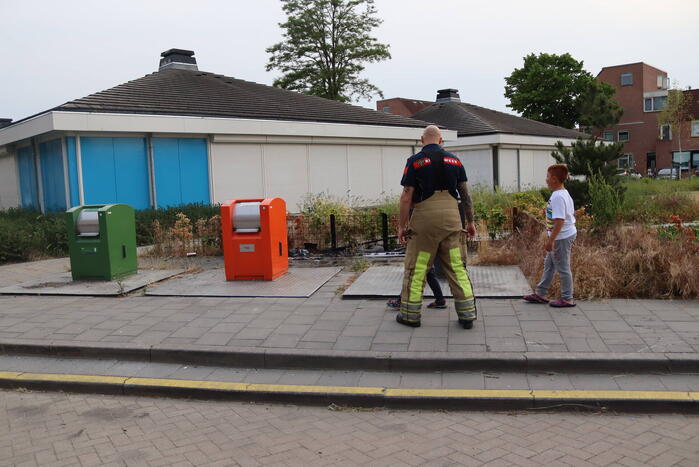 Gedumpt afval bij containers in brand