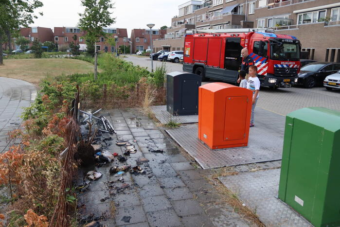 Gedumpt afval bij containers in brand