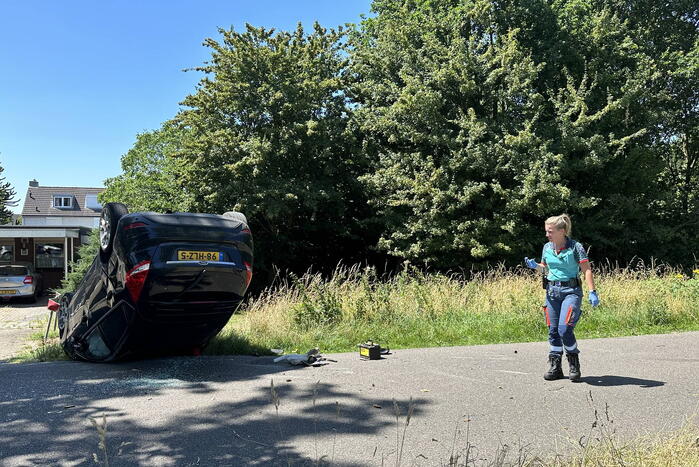 Auto belandt op de kop na botsing tegen boom