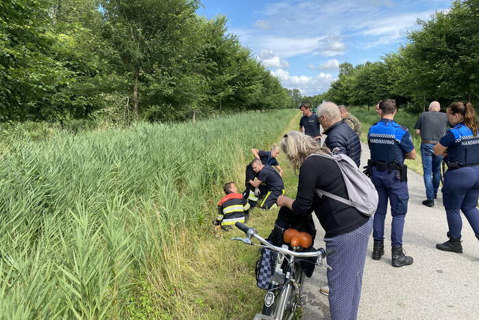 Vrouw rijdt met driewieler de sloot