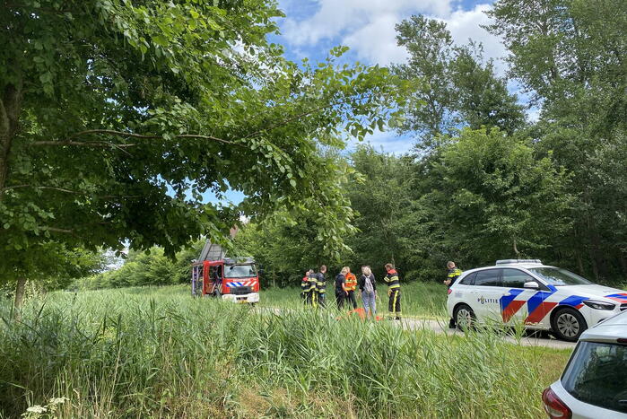 Vrouw rijdt met driewieler de sloot