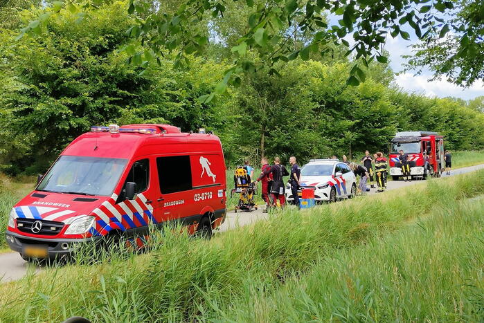 Vrouw rijdt met driewieler de sloot