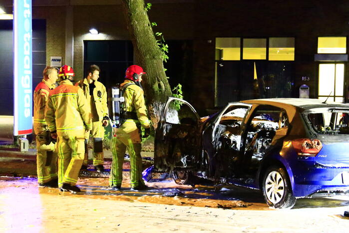 Auto in brand na frontale botsing tegen boom, twee gewonden