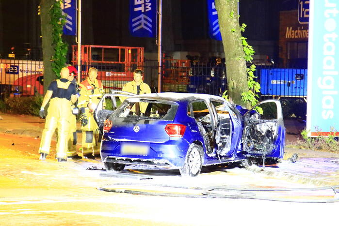 Auto in brand na frontale botsing tegen boom, twee gewonden