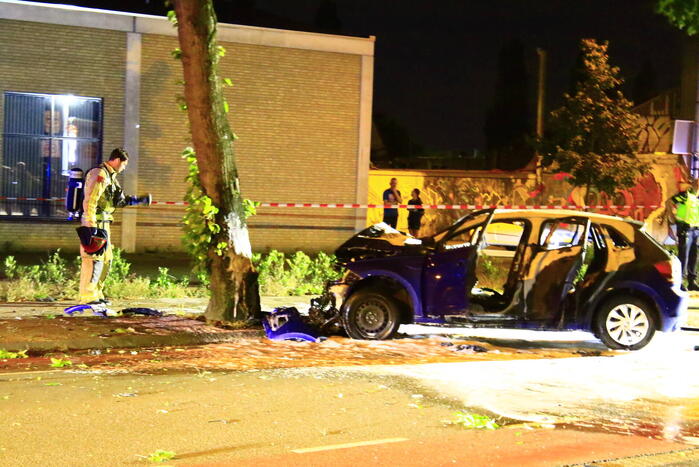 Auto in brand na frontale botsing tegen boom, twee gewonden