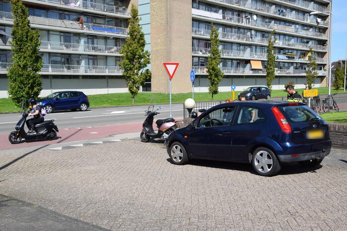 Automobilist en scooterrijder in botsing