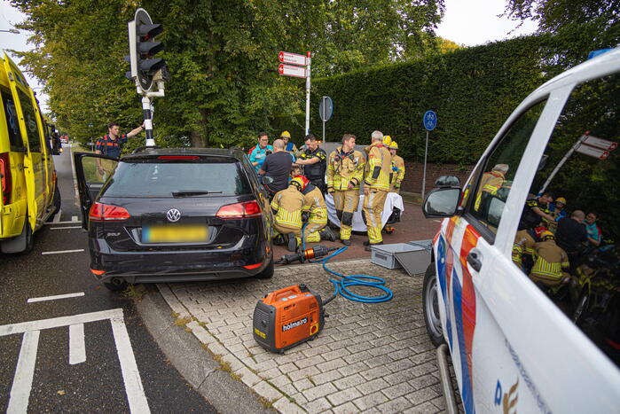 Fietser bekneld tussen auto en paal