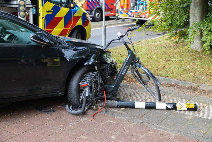 Fietser bekneld tussen auto en paal