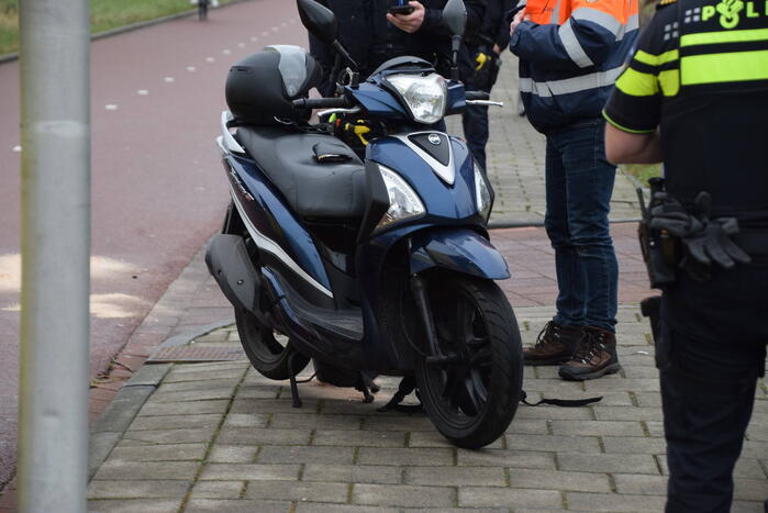 Fietser en scooterrijder botsen