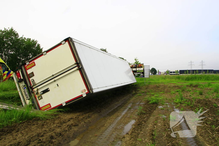 Vrachtwagen op zijn kant in sloot