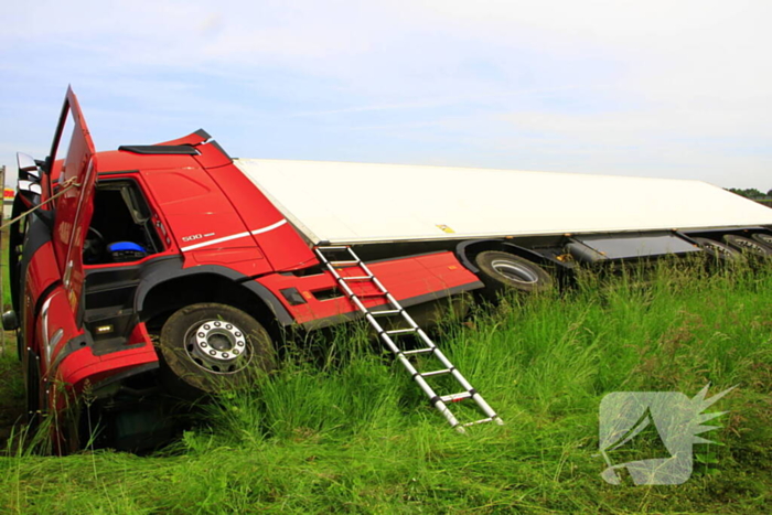 Vrachtwagen op zijn kant in sloot