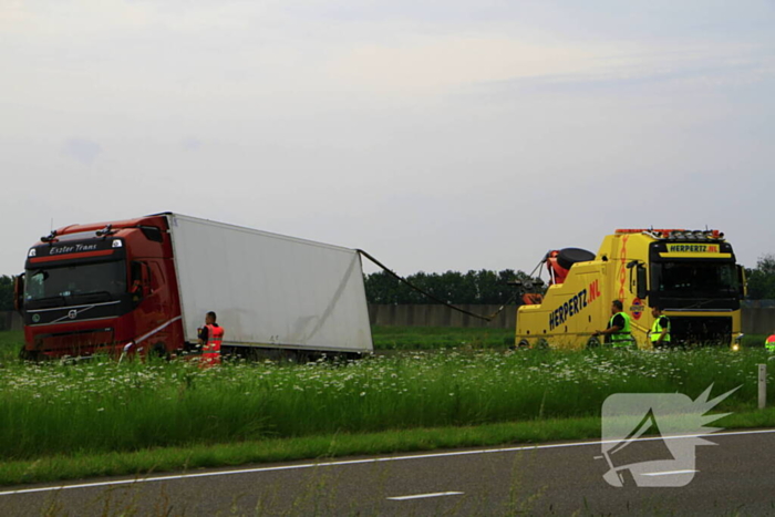 Vrachtwagen op zijn kant in sloot