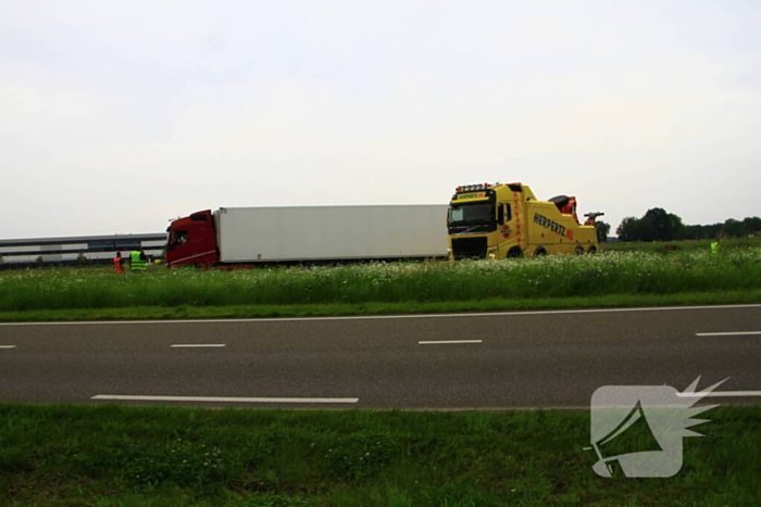 Vrachtwagen op zijn kant in sloot