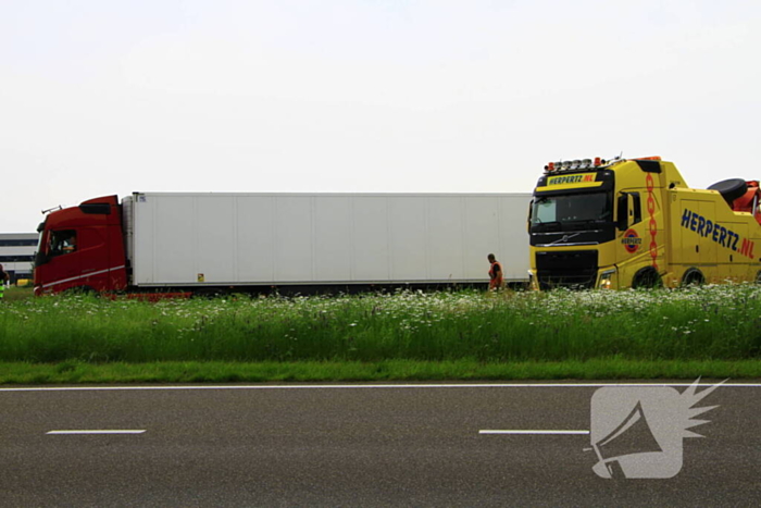 Vrachtwagen op zijn kant in sloot