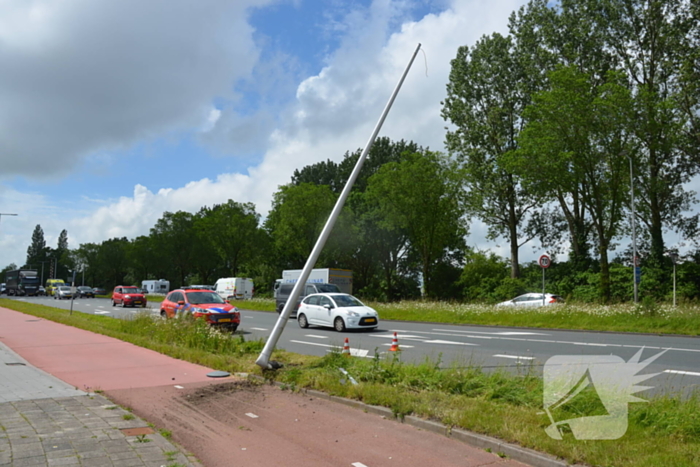 Automobilist rijdt tegen lantaarnpaal en hekwerk