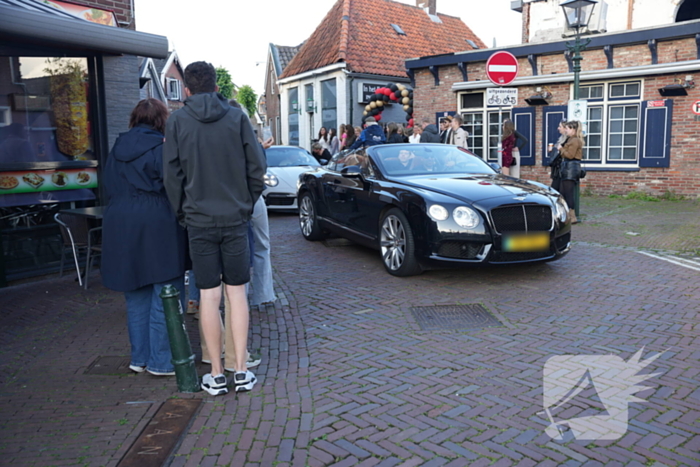 Leerlingen komen in bijzondere auto's aan bij examenfeest