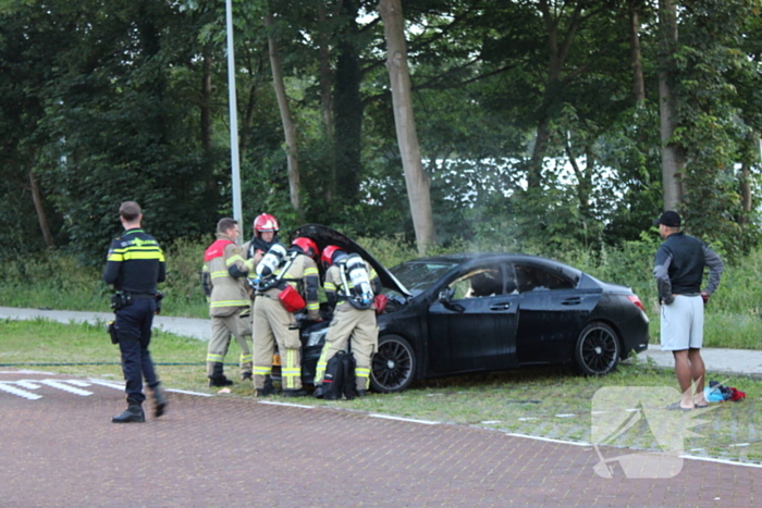 Brandweer blust brand in geparkeerde auto