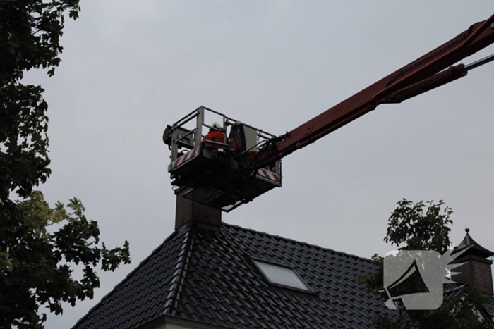 Brandweer veegt schoorsteen na brand