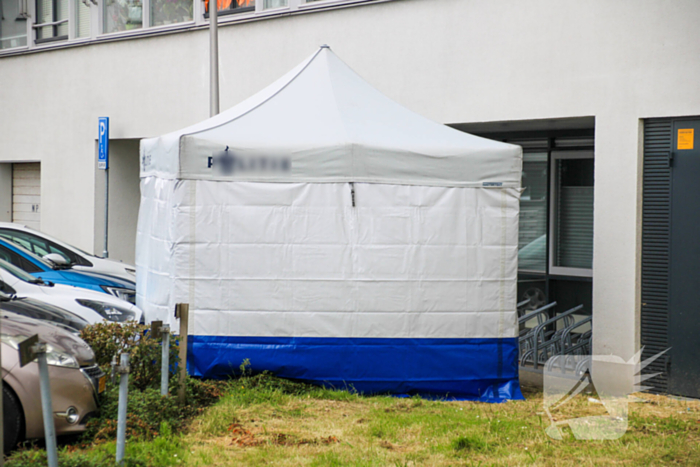 Forensisch onderzoek op parkeerplaats naast flatgebouw