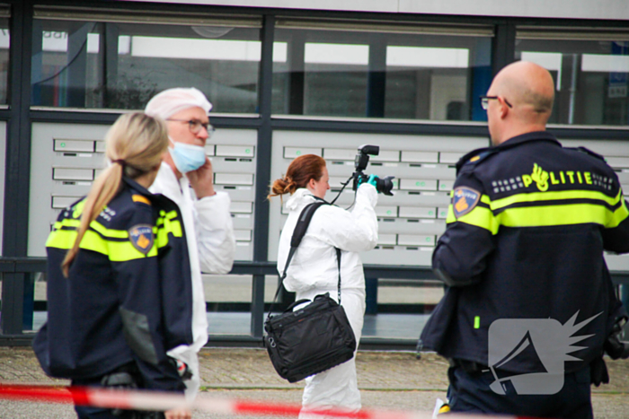 Forensisch onderzoek op parkeerplaats naast flatgebouw