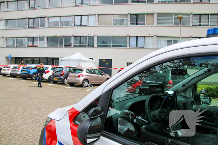 Forensisch onderzoek op parkeerplaats naast flatgebouw