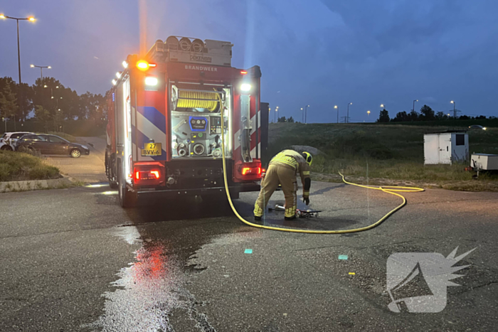 Brandweer blust in brand gestoken bouwkeet vol rommel