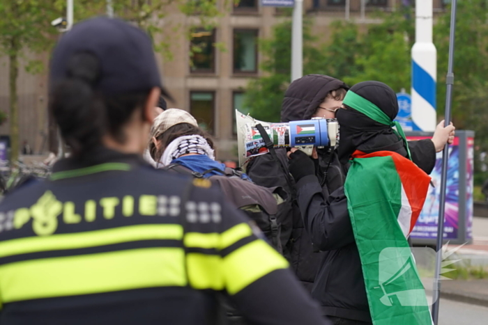 Demonstranten trekken persoon van scooter en slaan op auto's