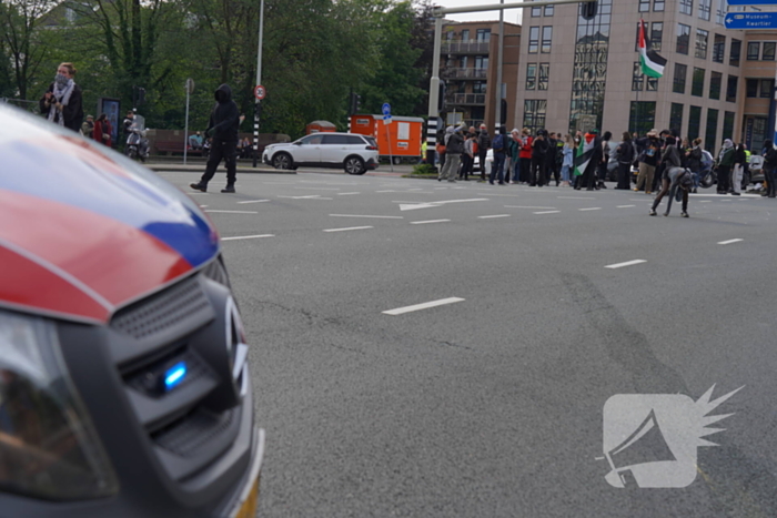 Demonstranten trekken persoon van scooter en slaan op auto's