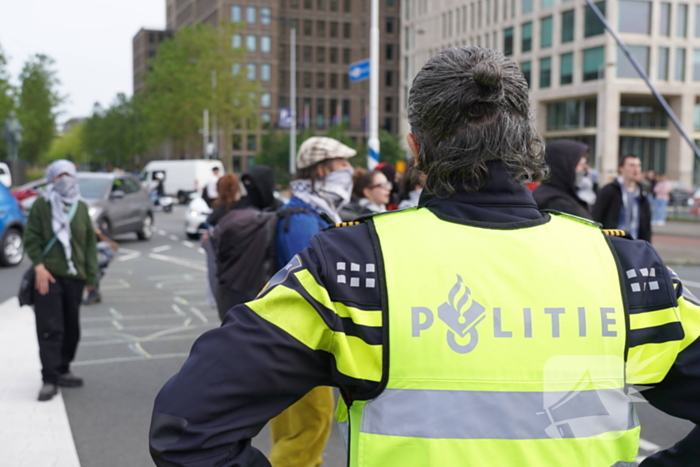 Demonstranten trekken persoon van scooter en slaan op auto's