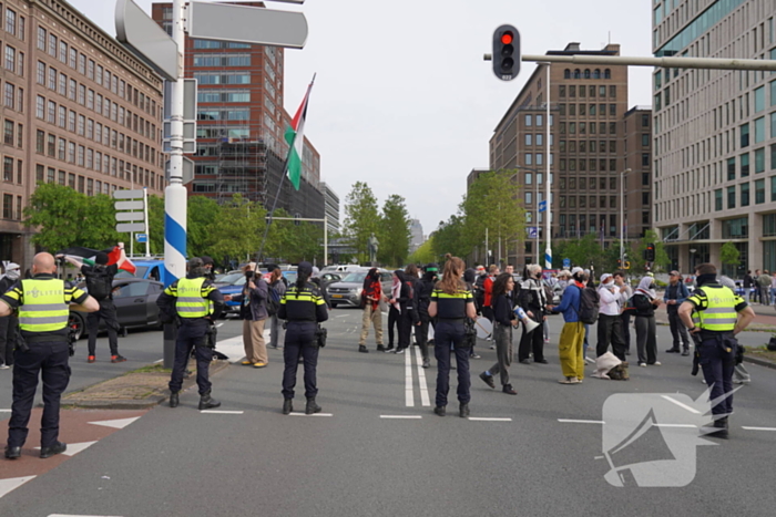 Demonstranten trekken persoon van scooter en slaan op auto's