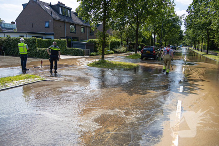 Straat blank door een gesprongen waterleiding