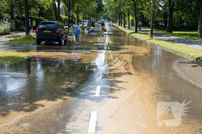 Straat blank door een gesprongen waterleiding