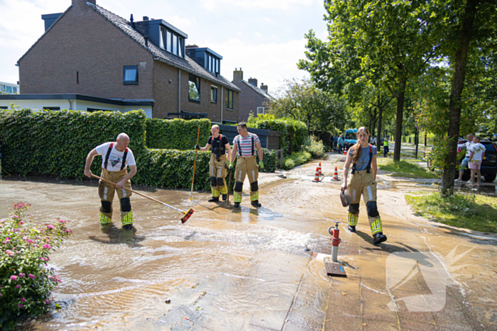 Straat blank door een gesprongen waterleiding