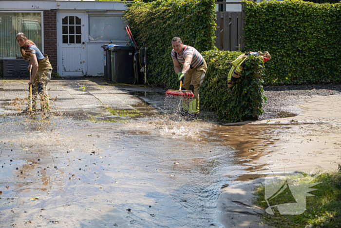 Straat blank door een gesprongen waterleiding