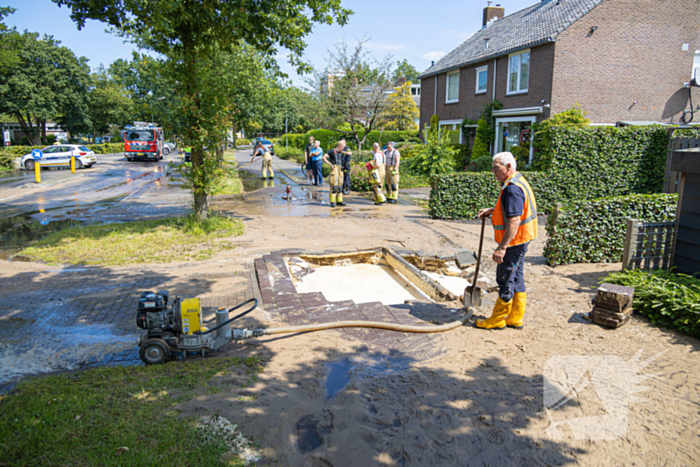 Straat blank door een gesprongen waterleiding