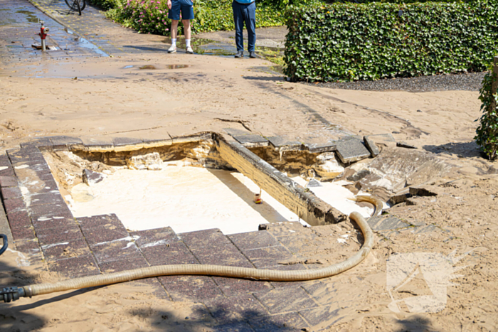 Straat blank door een gesprongen waterleiding