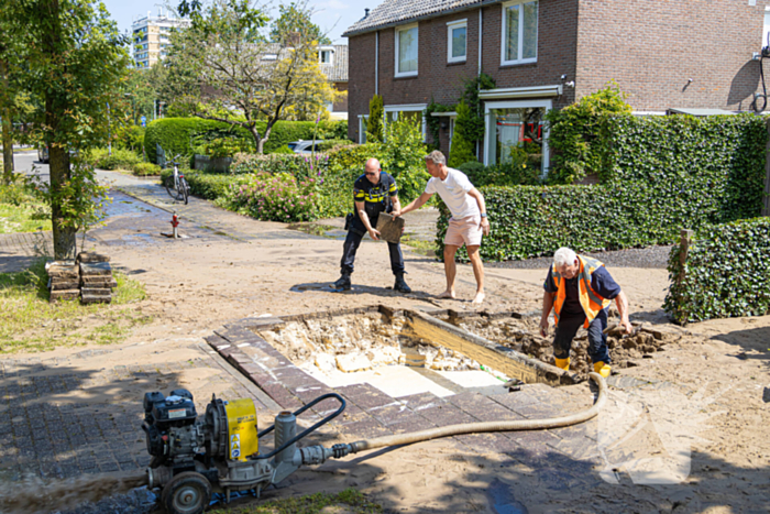 Straat blank door een gesprongen waterleiding