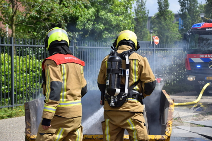 Brandweer blust brand in bouwcontainer