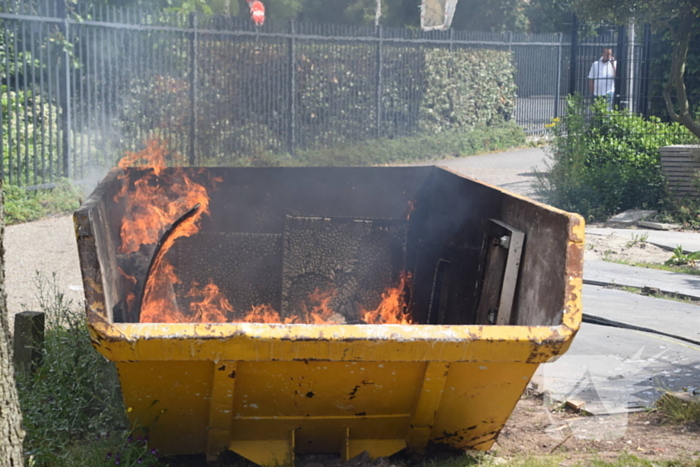 Brandweer blust brand in bouwcontainer