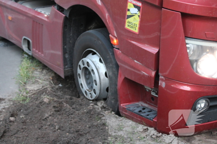 Vrachtwagen rijdt zich vast in berm