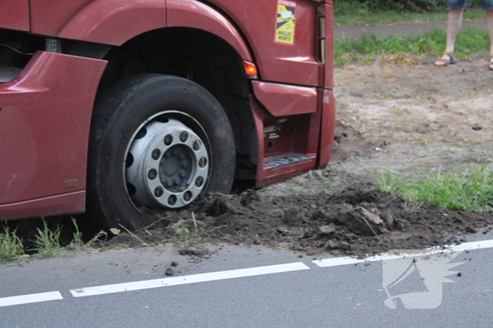 Vrachtwagen rijdt zich vast in berm