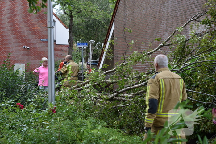 Boom waait tegen woning