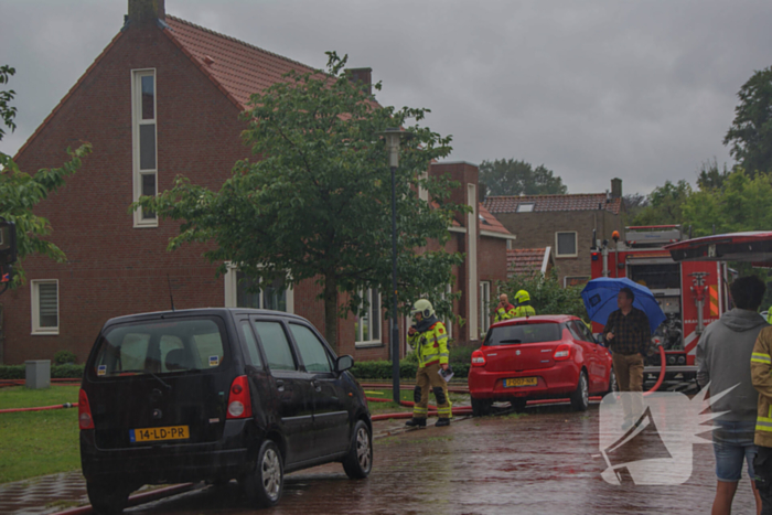 Autobrand slaat over naar schuren, bewoner ademt rook in bij bluspoging