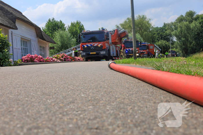 Brandweer blust brand in rietenkap van woning